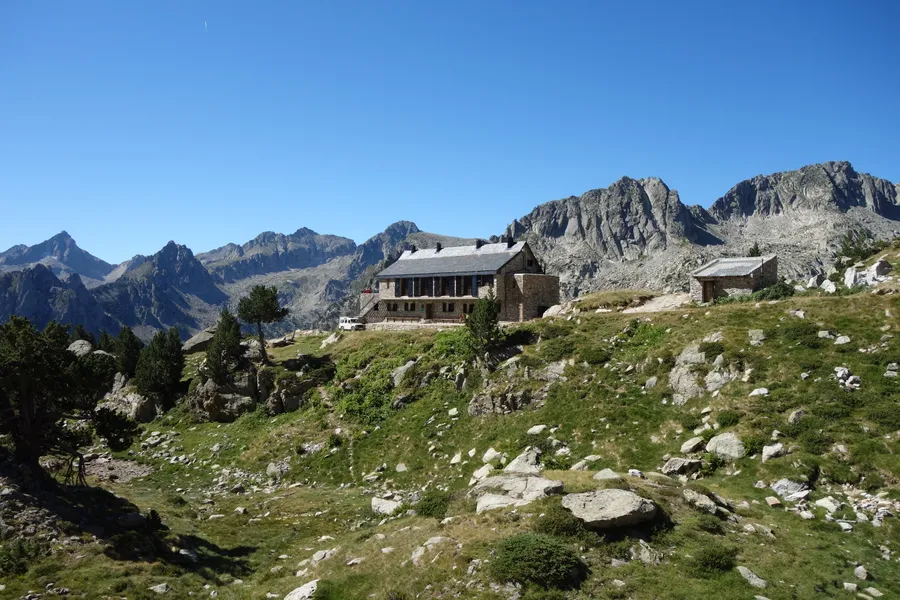 El refugio de Amitges sobre la plataforma granítica, con las agujas del circo al fondo, Parc Nacional d'Aigüestortes