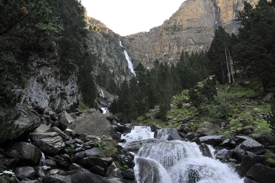 La cascada de Cotatuero cayendo por la pared caliza del fondo del circo, vista desde el cauce del barranco, valle de Ordesa, Parque Nacional de Ordesa y Monte Perdido